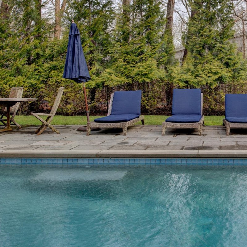 Lounge by the glistening heated pool, cool drink in hand