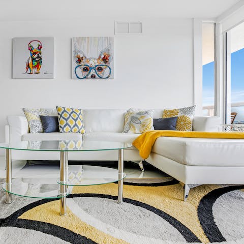 Kick back and relax in the bright living room, decorated in sleek whites and funky artwork