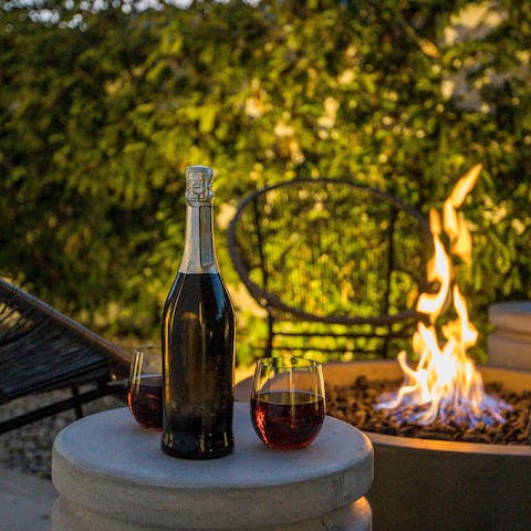 Cosy up with a glass of your favourite tipple in front of the open fire pit 