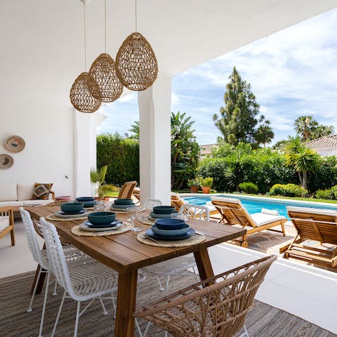 Share tapas and empanadas on the cute table under the pergola