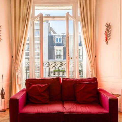 Curl up on the sofa and gaze out at the charming Parisian buildings