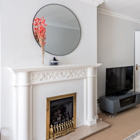 Gather around the living room's charming fireplace for an evening in