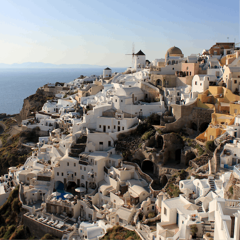 Explore beautiful Oia, perched on a steep slope of the caldera, a twenty-minute drive away