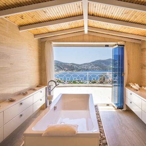 Relax in the freestanding bathtub at the end of a busy day, with the sea and mountains before you