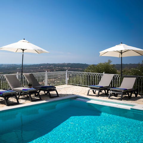 Relax on a sun lounger by the outdoor pool while you enjoy the views over Kefalonia