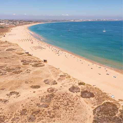 Discover the soft sands and rocky cliffs of Porto Mós Beach 