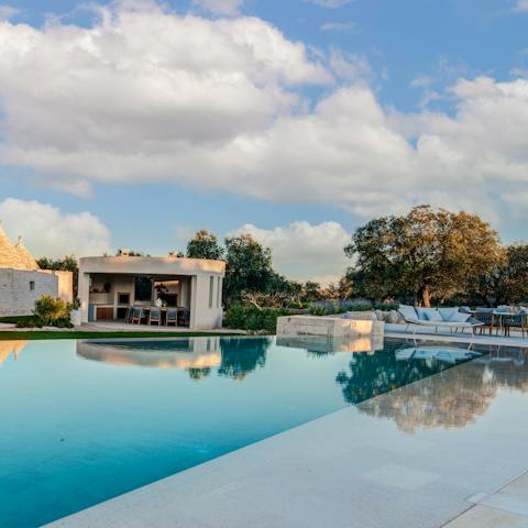 Kick back and relax by the luxurious pool, glass of wine in hand