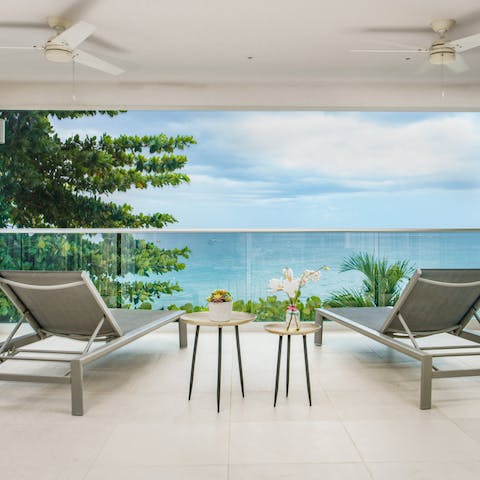 Laze on loungers on your covered terrace while gazing out to sea