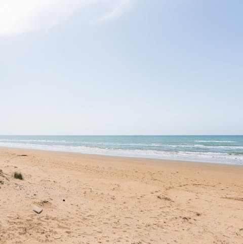 Paddle the shallow waters of Santa Maria Del Focallo Beach, just 300m away