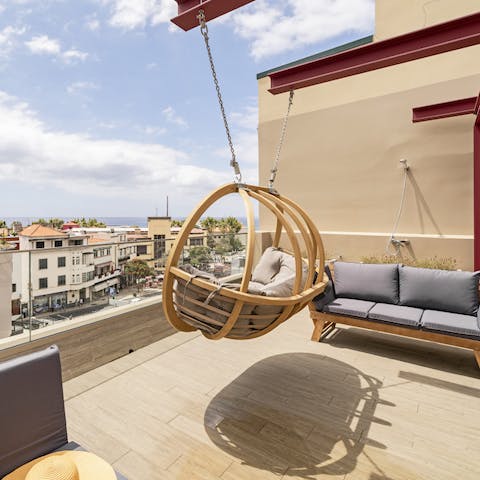 Relax with a cocktail on the rooftop swing chair while you look out to sea