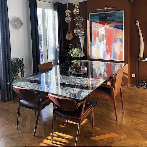 Eat dinner on the striking dining table surrounded by unique artworks
