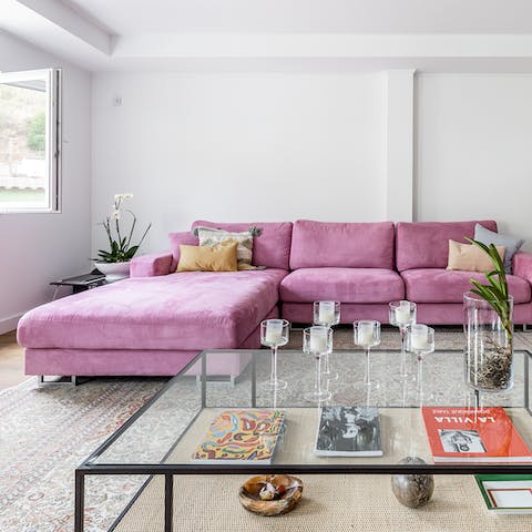 Relax with a book on the plush pink sofa after a day of exploring Lisbon