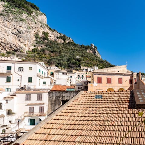 Look out over old tiled rooftops and the town's craggy cliff face