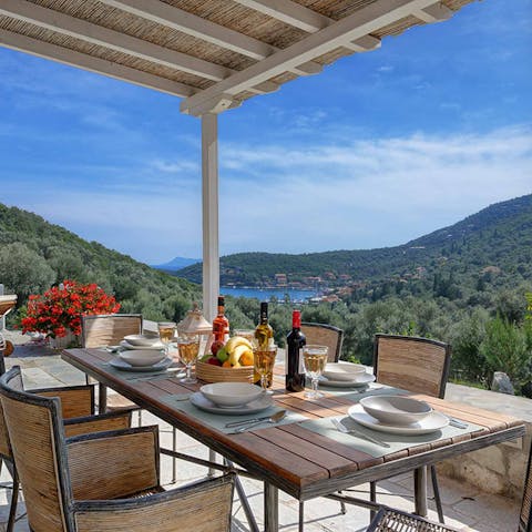 Dine alfresco on the covered poolside terrace while admiring  gorgeous Greek views