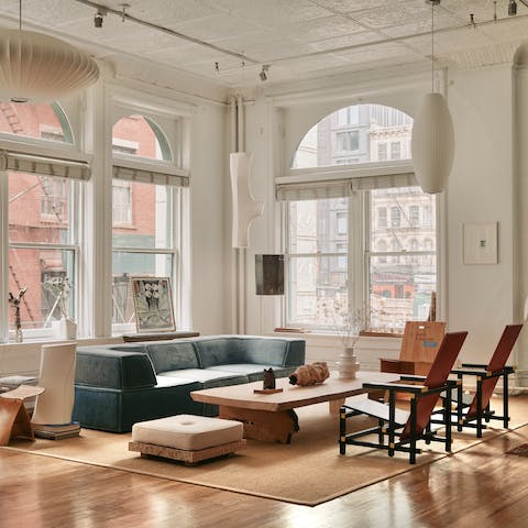 Relax on the large sofa in this light loft with its huge, arched windows