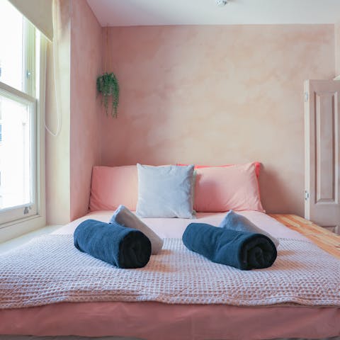 Sleep soundly surrounded by the soothing pink tones of the bedroom