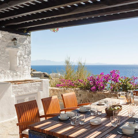 Dine alfresco under the pergola as the sun goes down over the water