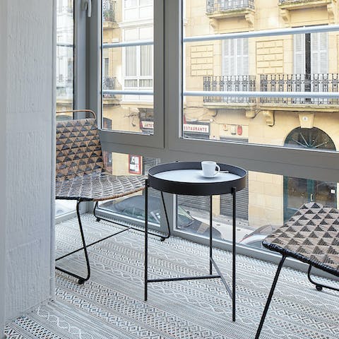 Enjoy a coffee while taking in the street views from the covered balcony