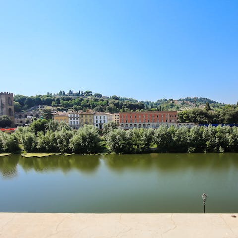 Admire the view of the Arno River as you savour a glass of wine