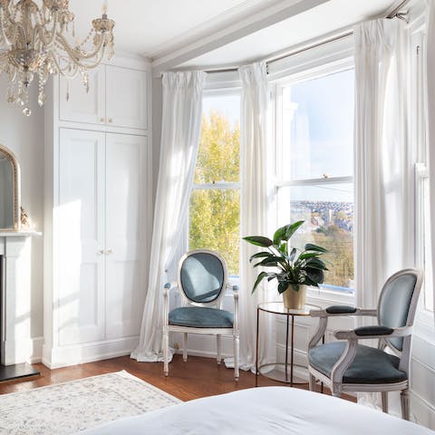 Read a book in the well-lit bay window of the elegant master bedroom