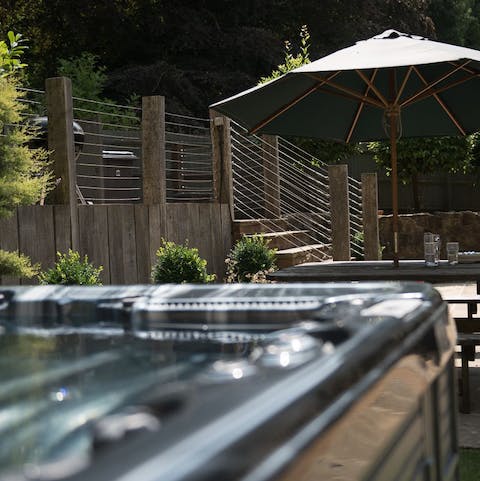Unwind in the hot tub overlooking the beautiful garden setting