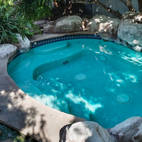Cool down or warm up on the backyard spa jacuzzi  –⁠ there's room for all thirteen of you 
