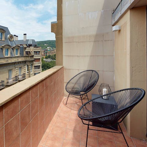Relax on the sun-filled private terrace overlooking the elegant street below