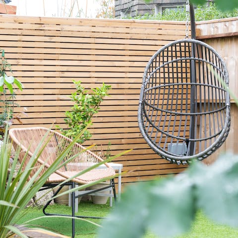 Relax with a glass of wine in the hanging chair in the garden