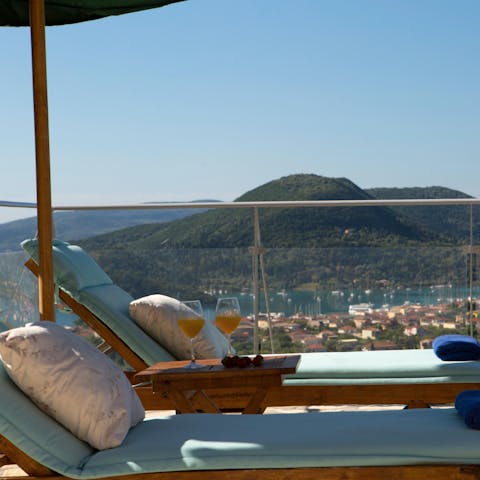 Relax on a sun lounger overlooking the  Greek islands