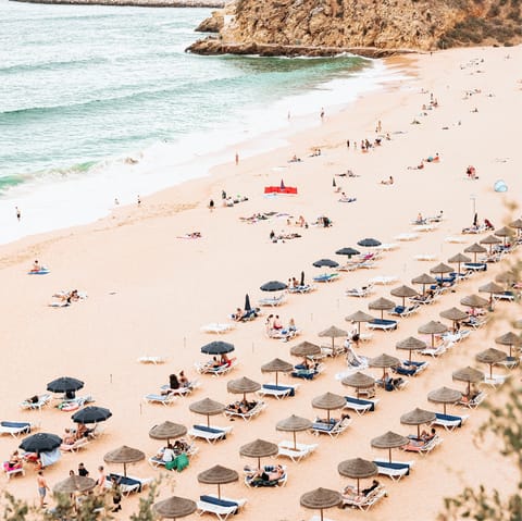 Visit the scenic sands and cliffs of Porto Mós Beach for a day trip