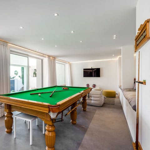 Play a round of pool on the billards table with views of the pool and garden