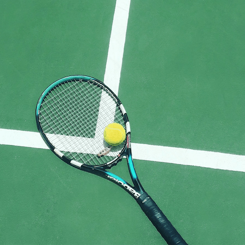 Pick up the rackets provided and head to the shared tennis court for a friendly game 