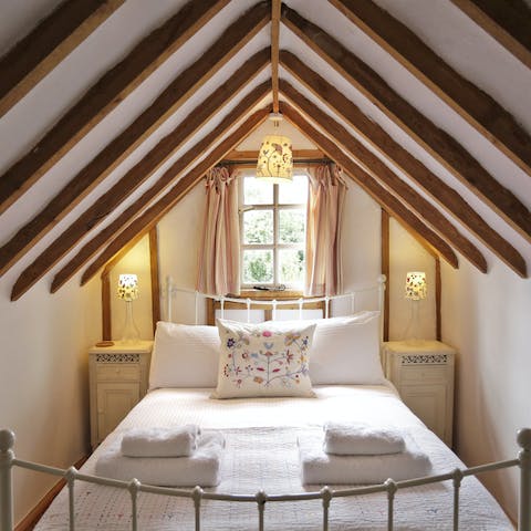 Fall asleep under the timber beamed ceilings in the loft-style bedroom