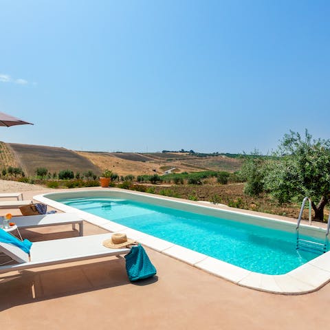 Spend blissful days lounging by the pool, taking in the vast Sicilian countryside view