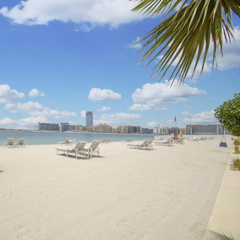 Relax on a sun lounger on the resort's private beach while you gaze at the views of the city