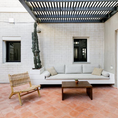 Relax on the outdoor sofa, in the dappled shade of the pergola
