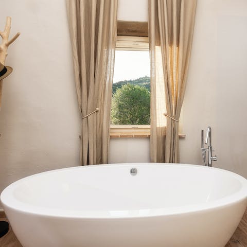 Treat yourself to an indulgent bubble bath in the freestanding tub with idyllic rural views