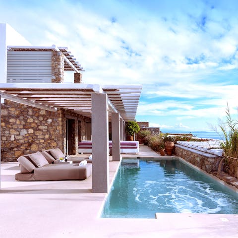 Lounge by the poolside and take in the Aegean Sea views