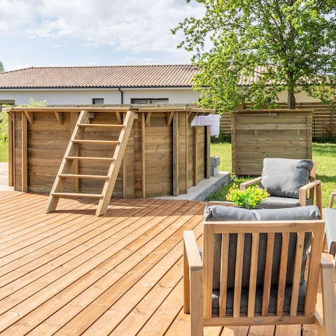Relax in the garden with comfy furnishings and a wooden above-the-ground swimming pool