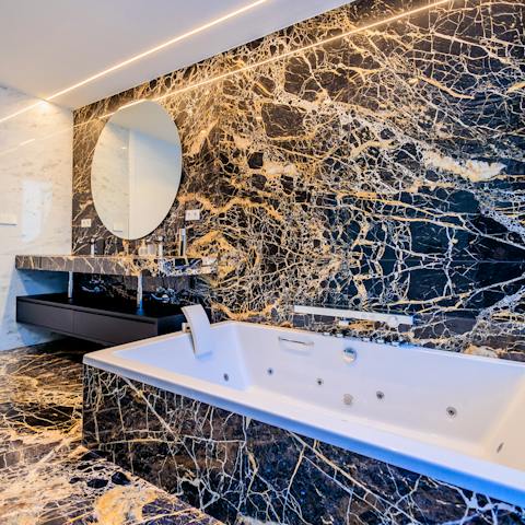 Unwind in the luxurious Jacuzzi bathtub in the marble bathroom