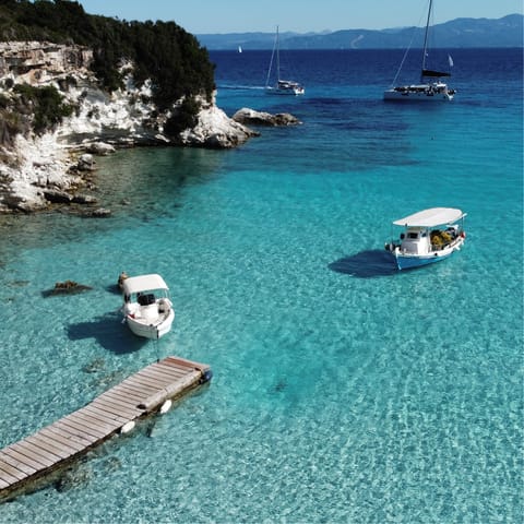 Visit the white sands and turquoise waters of Voutoumi Beach by boat