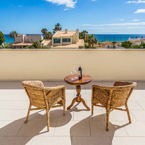 Sip on a glass of wine as you drink in the sea views from the terrace