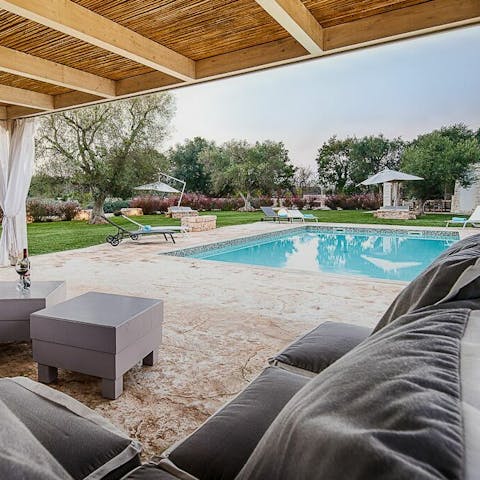 Relax at the poolside lounge area with a glass of Prosecco in hand