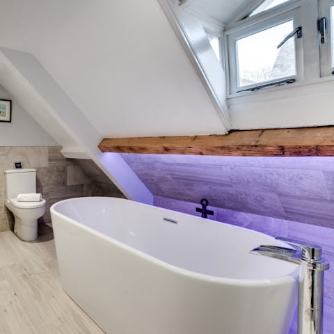 Relax and unwind in the large freestanding tub with mood lighting