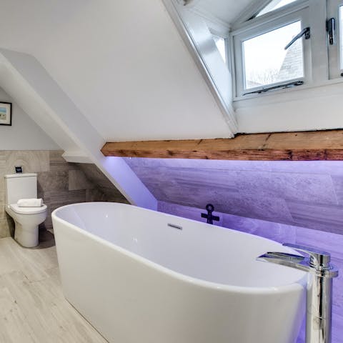 Relax and unwind in the large freestanding tub with mood lighting