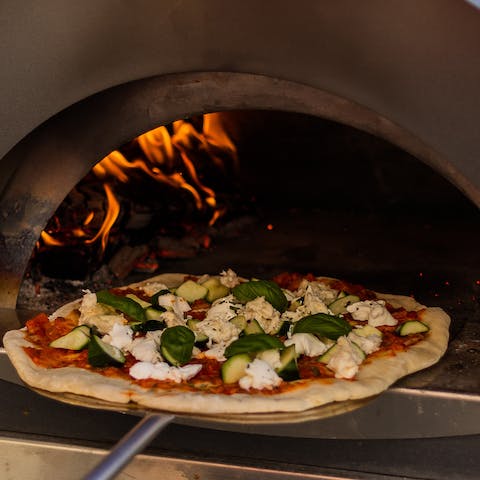 Make delicious pizzas from scratch and cook them to perfection in the garden's pizza oven