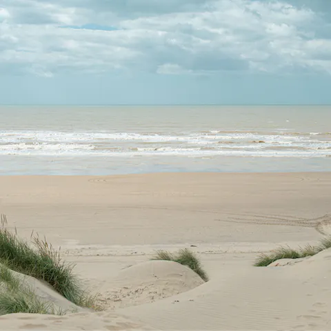 Dip your toes in the ocean waves at Camber Sands, a twenty-minute drive away