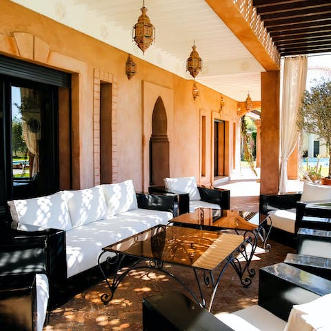 Relax in the outdoor seating in the shade of the terrace, and look out at the pool and grounds