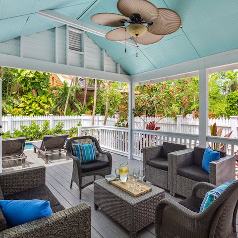 Enjoy casual late afternoon tipples in the seating area beneath the pergola after a day of exploring Key West