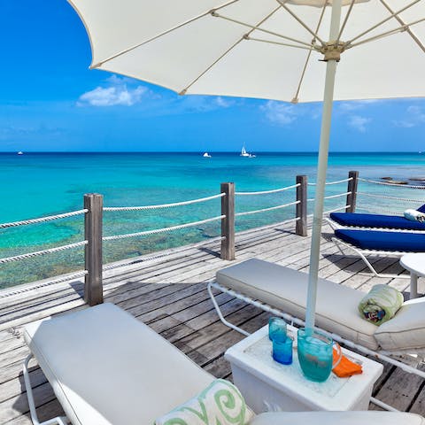 Lounge under the shade on your deck, a few feet from the waves